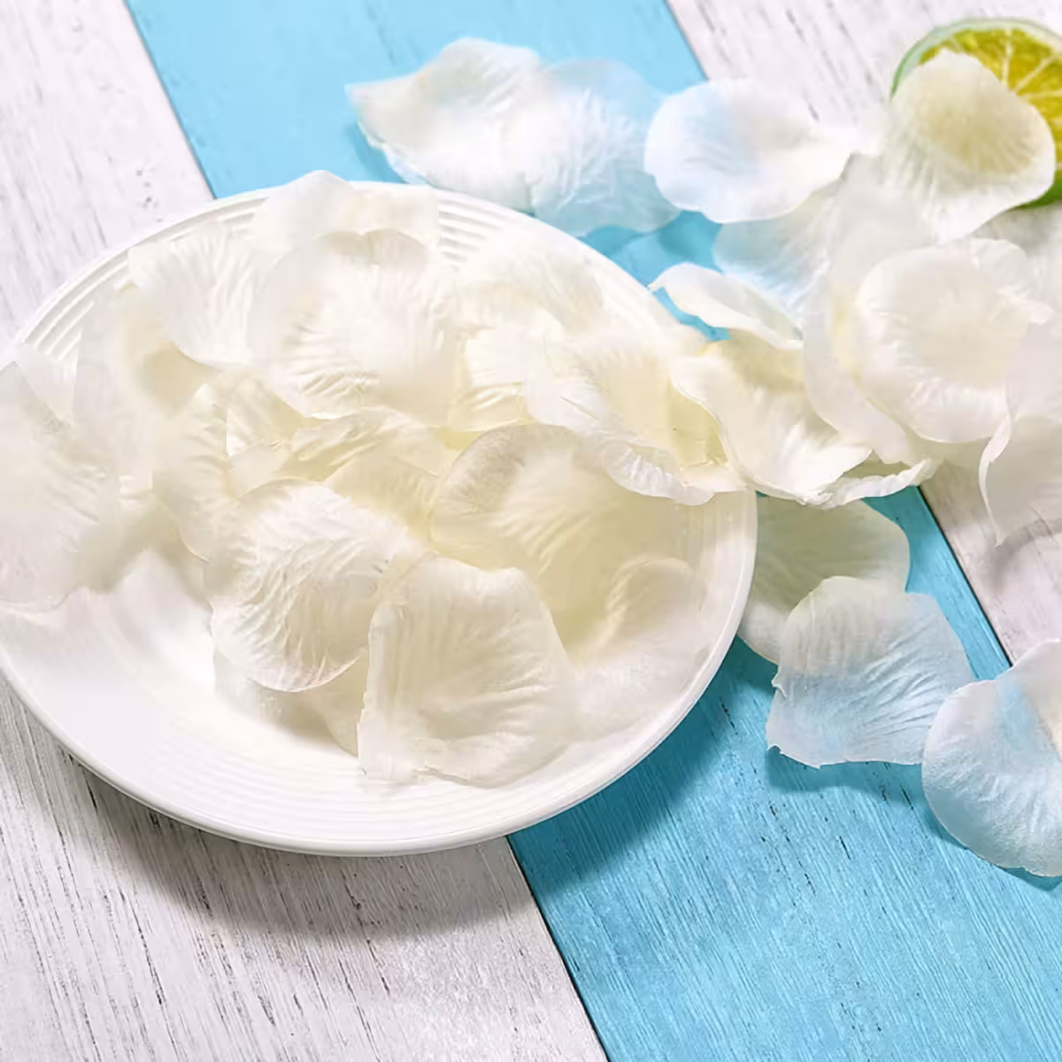 Valkoiset tekstiilipetalit levitettynä lattialle eleganttiin koristeluun